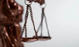 Waga sprawiedliwości, symbol równowagi. Obok niej widać fragment posągu Temidy, symbolizującej prawo. To metafora dla jednostki organizacyjnej nieposiadającej osobowości prawnej, która działa w ramach prawa.