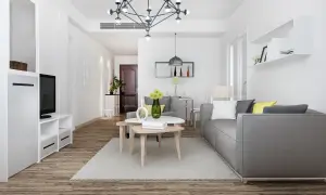 Nowoczesny salon z szarą kanapą i stolikami kawowymi. Idealne miejsce na pkd wynajem krótkoterminowy.