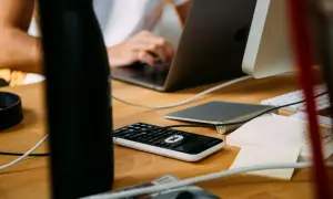 Biurko z laptopem, kalkulatorem i notatkami. Idealne miejsce do pracy zdalnej, gdzie sprzedaż detaliczna prowadzona przez domy sprzedaży wysyłkowej lub inte... jest na wyciągnięcie ręki.