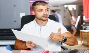 Mężczyzna z dokumentem i kciukiem w górze, pokazujący jak znaleźć kod PKD.