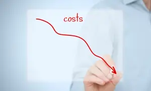 Ręka rysuje czerwoną linię spadkową, symbolizującą redukcję kosztów ogólnego zarządu.