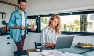 Para dowiedzieć się, jak dodać PKD przez profil zaufany, kobieta pracuje przy laptopie, a mężczyzna podaje jej kawę.