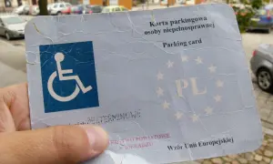 Karta parkingowa osoby niepełnosprawnej z symbolem wózka inwalidzkiego i napisem "PL". Umożliwia korzystanie z miejsca parkingowego dla osób niepełnosprawnych.