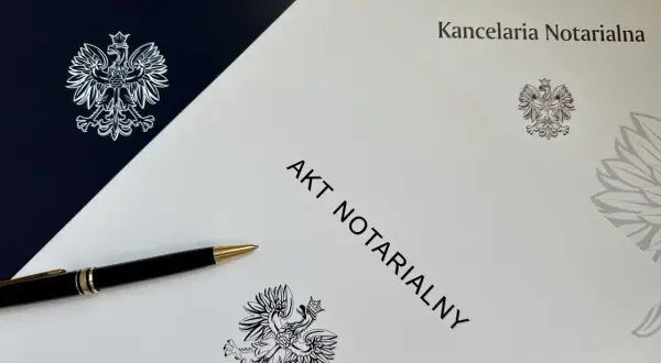 Akt notarialny i długopis na tle dokumentów kancelarii notarialnej. Szukasz informacji, jak znaleźć akt notarialny w internecie?