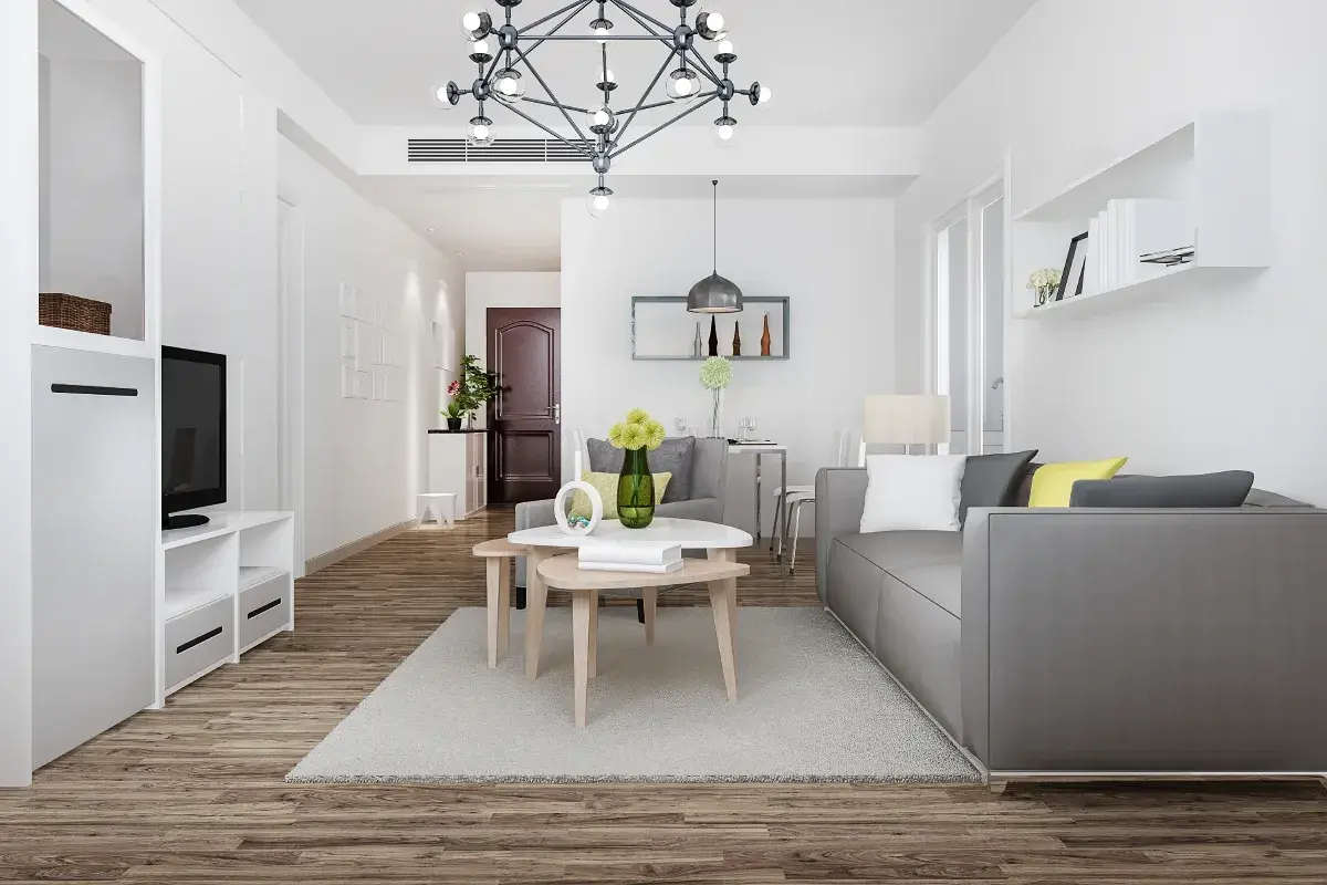 Nowoczesny salon z szarą kanapą i stolikami kawowymi. Idealne miejsce na pkd wynajem krótkoterminowy.