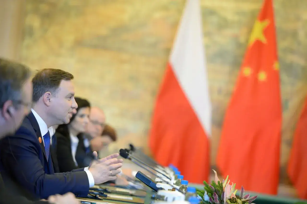 Prezydent Polski podczas spotkania z delegacją Chin. W tle flagi obu państw. Wyrażono zgodę na rozpowszechnianie wizerunku.