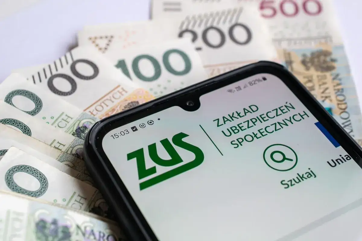 Telefon z aplikacją ZUS na tle polskich banknotów. Temat: częściowa niezdolność do pracy a renta.