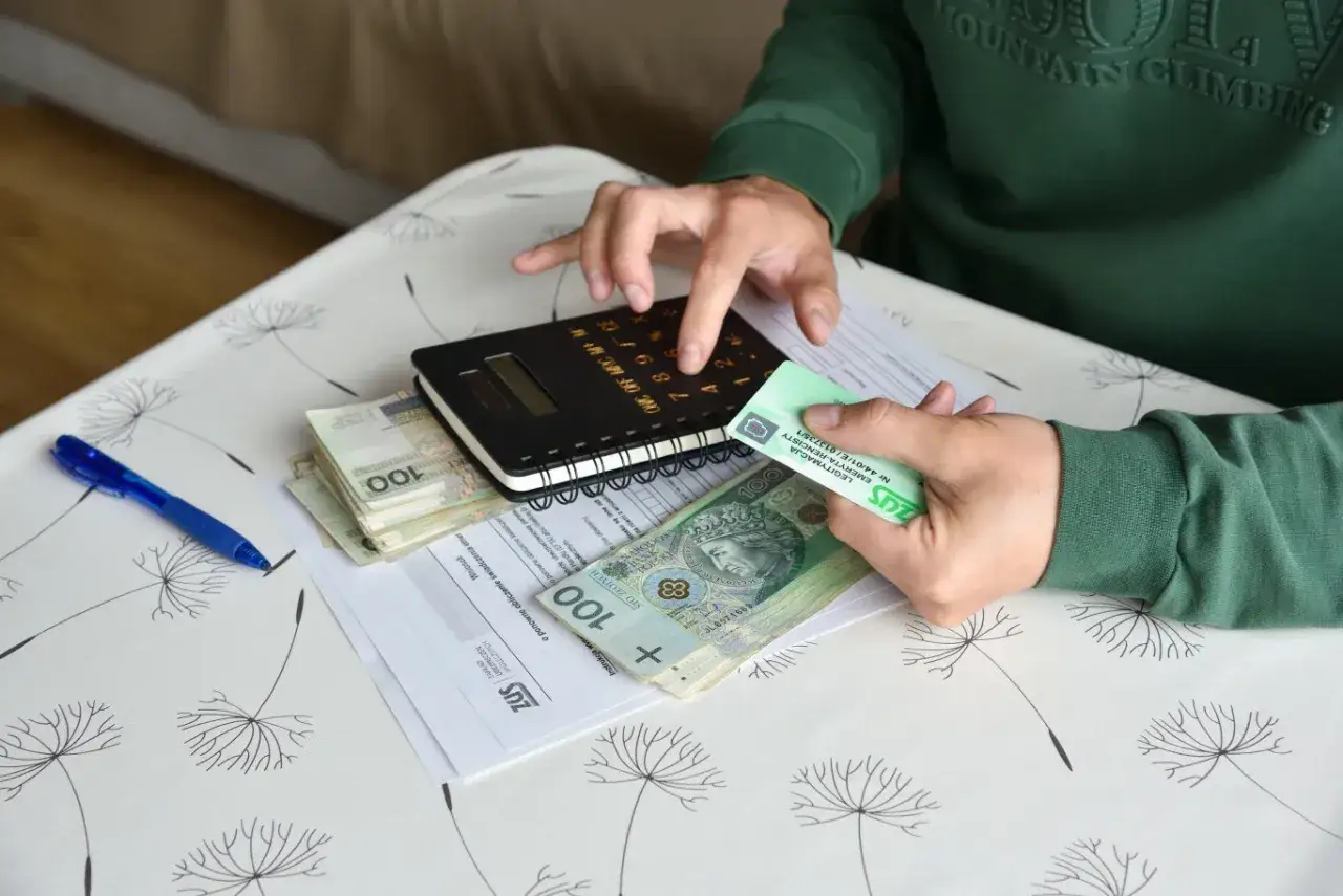 Częściowa niezdolność do pracy a renta. Rachunki, pieniądze i legitymacja ZUS na stole.