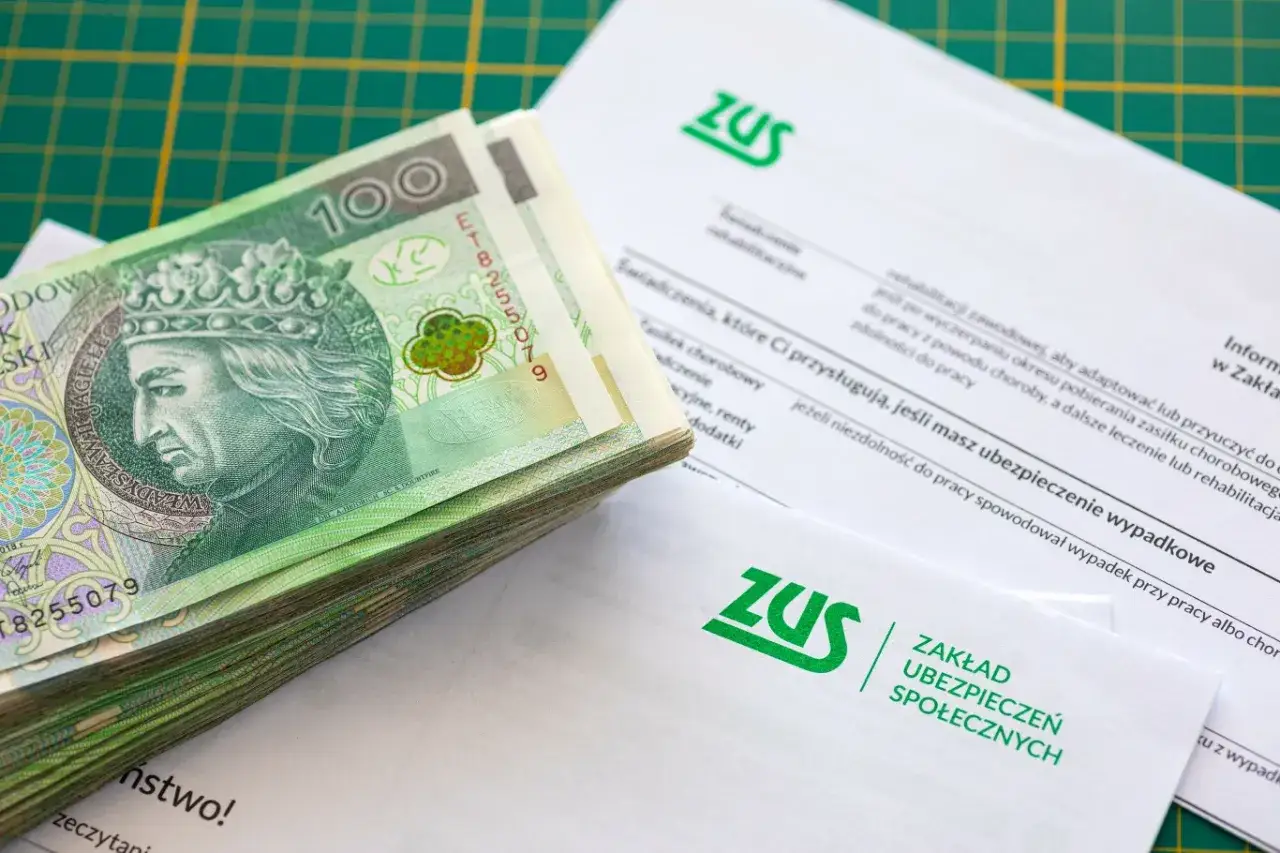 Stos banknotów obok dokumentów ZUS. Częściowa niezdolność do pracy a renta - kluczowe informacje na papierach.