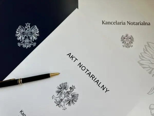 Akt notarialny i długopis na tle dokumentów kancelarii notarialnej. Szukasz informacji, jak znaleźć akt notarialny w internecie?